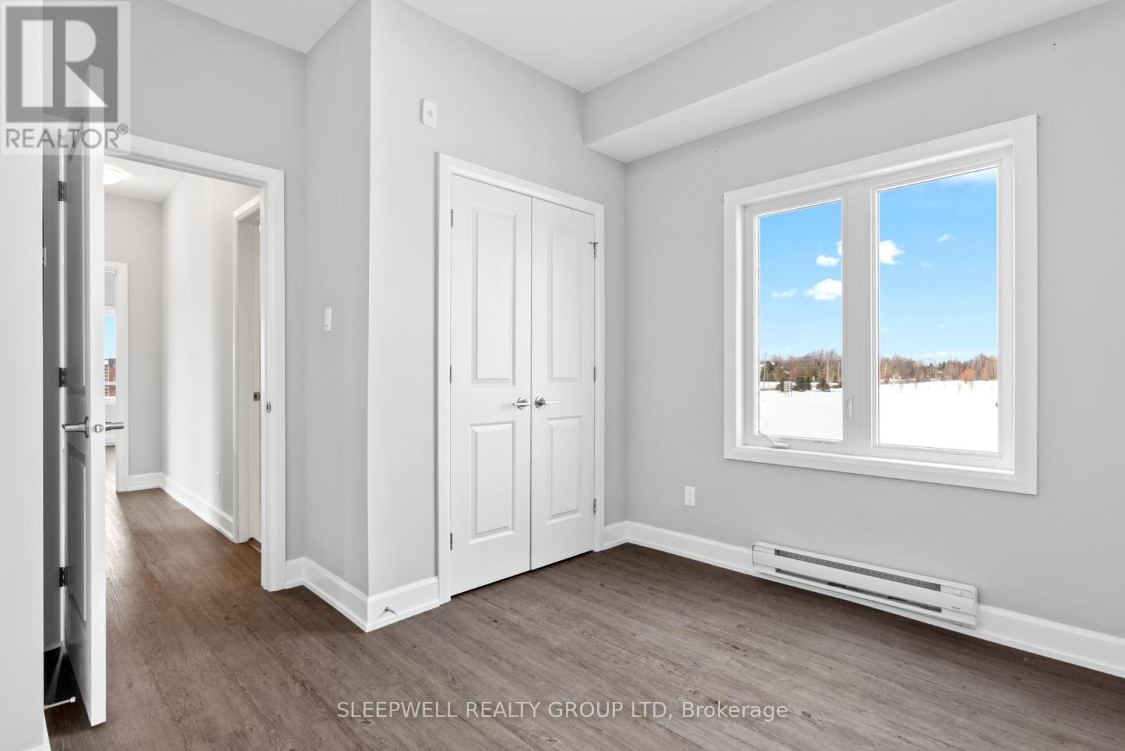 A room with a window showing a view of trees outside.