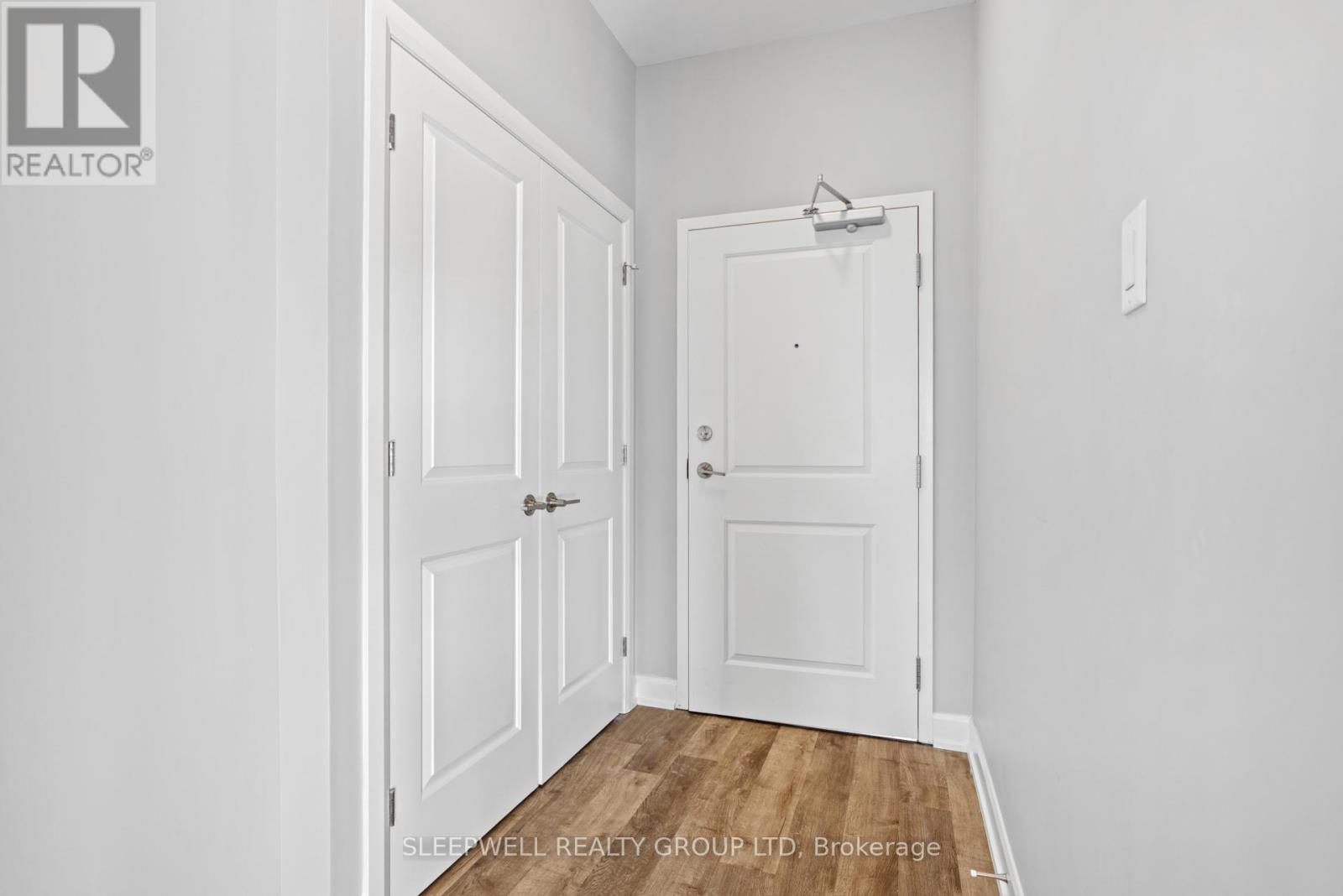 A white door is in a room with a wooden floor.