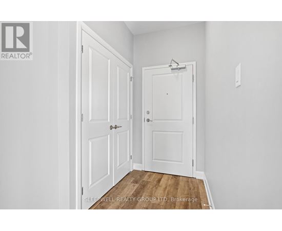 A white door is in a room with a wooden floor.