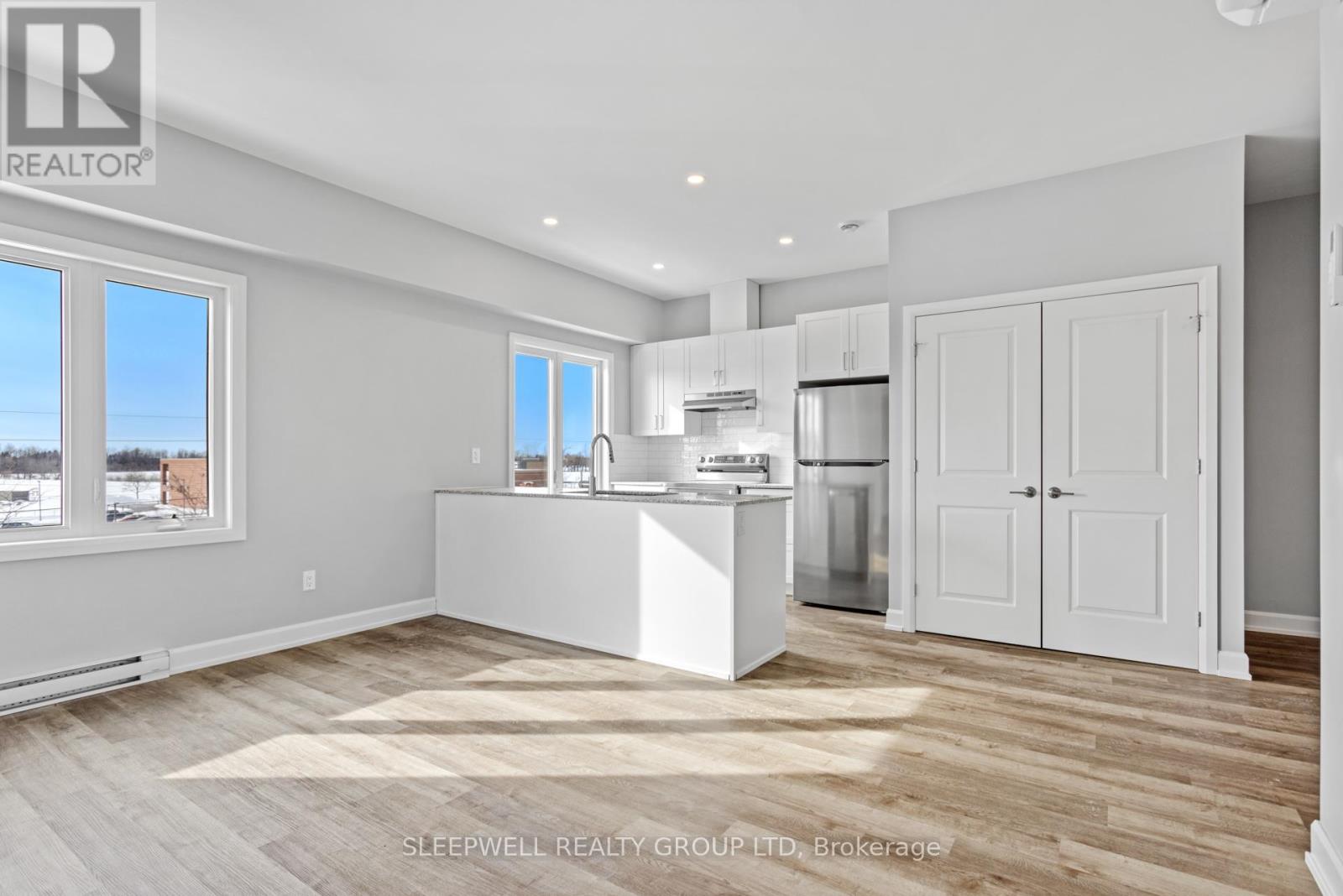 A kitchen with white appliances and cabinets is shown.