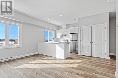 A kitchen with white appliances and cabinets is shown.
