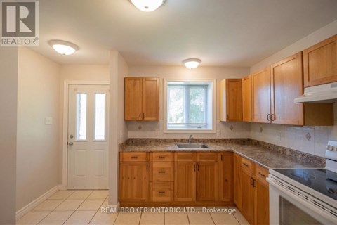 A kitchen with wooden cabinets and a white stove top oven.