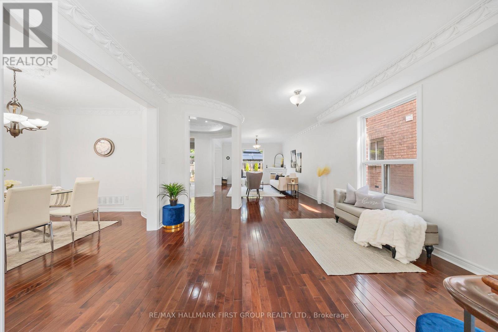A spacious living room with hardwood floors and white walls.