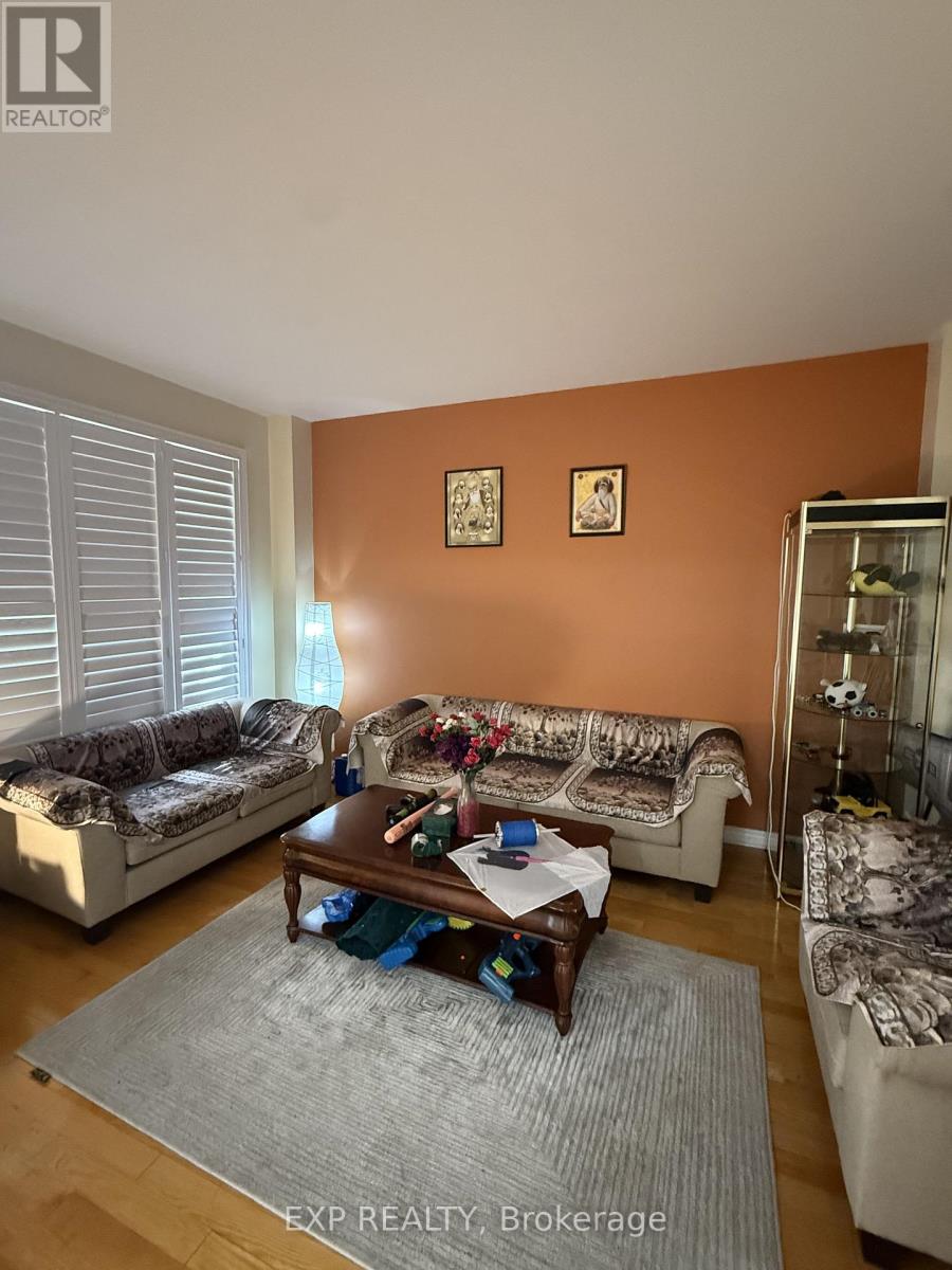 A living room with a couch, a chair, a coffee table, and a rug.