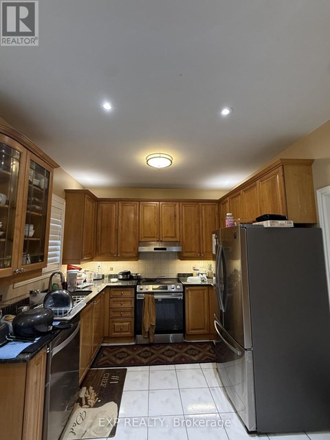 A kitchen with wooden cabinets and a refrigerator.