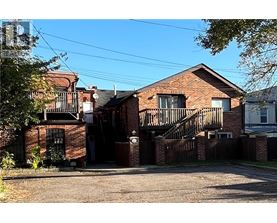 A red brick house with a black gate and a small porch.
