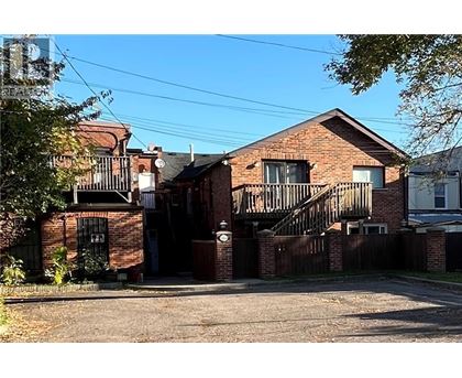 A red brick house with a black gate and a small porch.