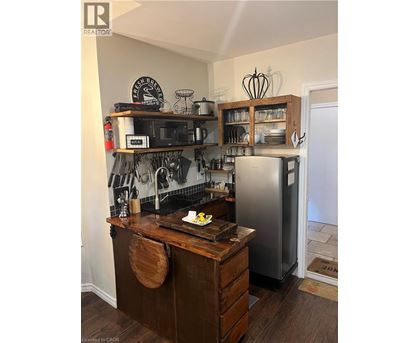 A kitchen with a wooden counter and a fridge.