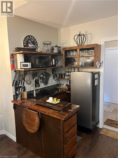 A kitchen with a wooden counter and a fridge.