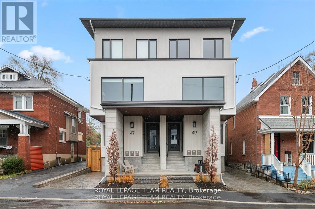 A modern two-story house with a balcony on the second floor is for sale.