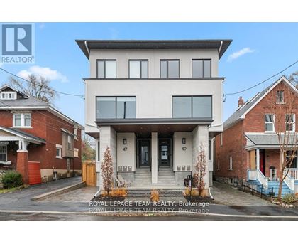 A modern two-story house with a balcony on the second floor is for sale.