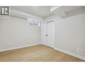 A white room with a wooden floor and a white door.