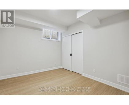 A white room with a wooden floor and a white door.