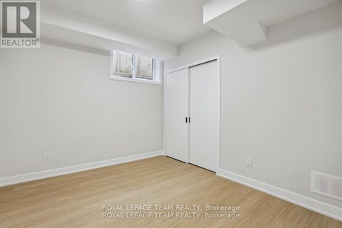 A white room with a wooden floor and a white door.