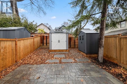 A backyard with a wooden fence and a shed.