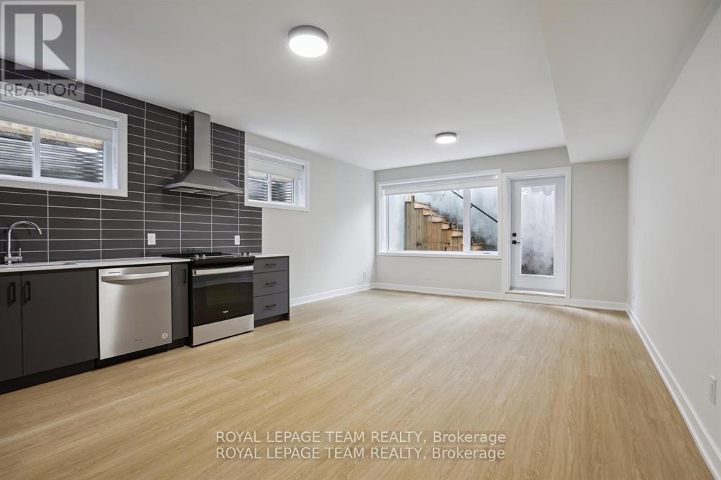 A kitchen with wooden floors and a stainless steel dishwasher.