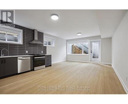 A kitchen with wooden floors and a stainless steel dishwasher.