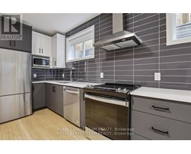 A modern kitchen with a stainless steel refrigerator, oven, and microwave.