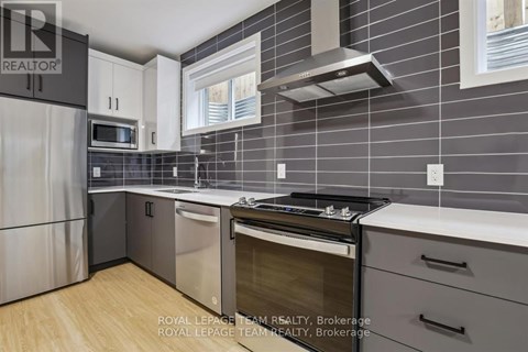 A modern kitchen with a stainless steel refrigerator, oven, and microwave.