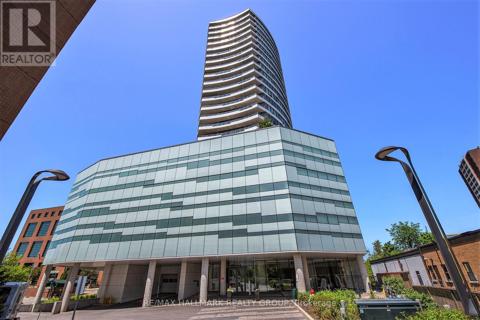 A modern building with a glass facade and a tall spire is the main focus of the image.