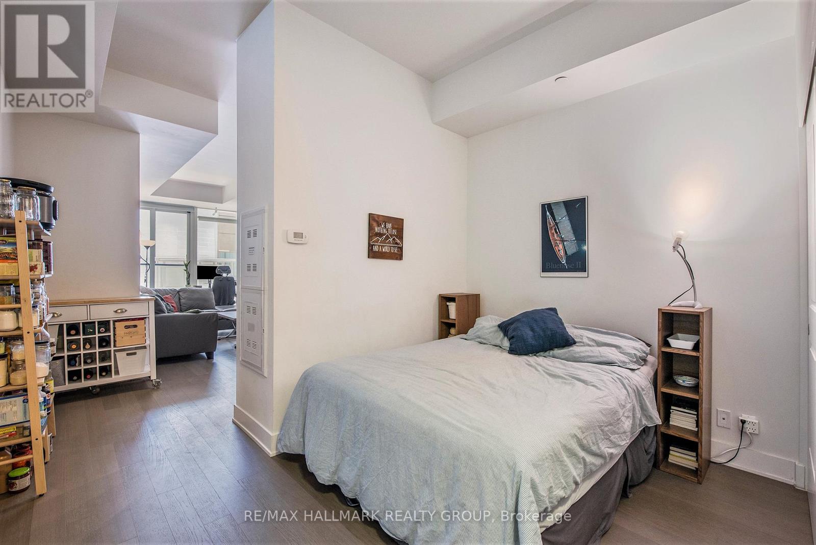 A bedroom with a bed, a nightstand, and a lamp.