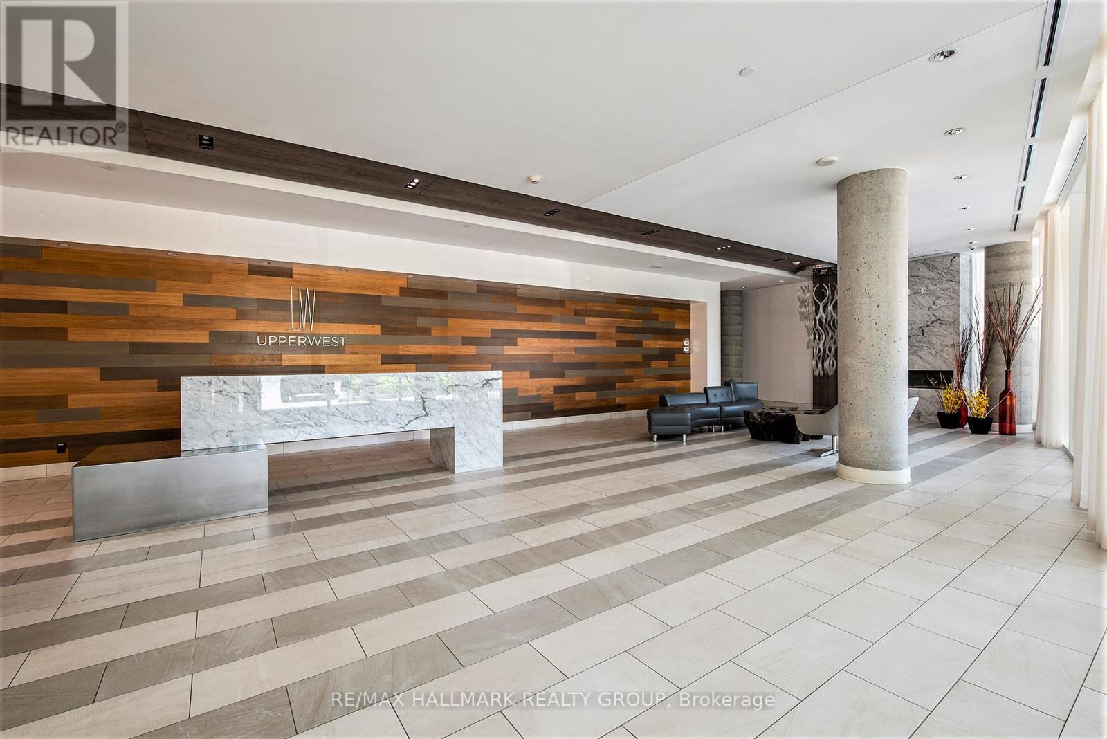 A spacious lobby with a reception desk and a large marble bench.