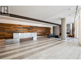 A spacious lobby with a reception desk and a large marble bench.