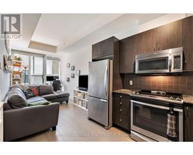 A modern kitchen with dark wood cabinets and stainless steel appliances.