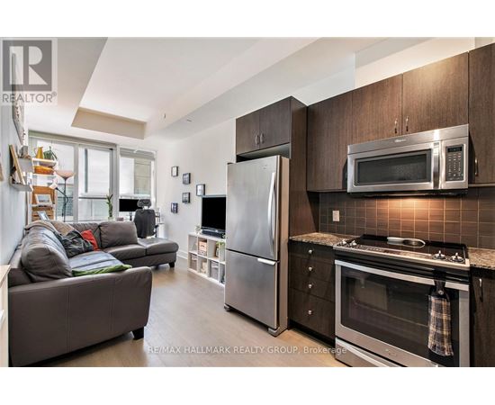A modern kitchen with dark wood cabinets and stainless steel appliances.