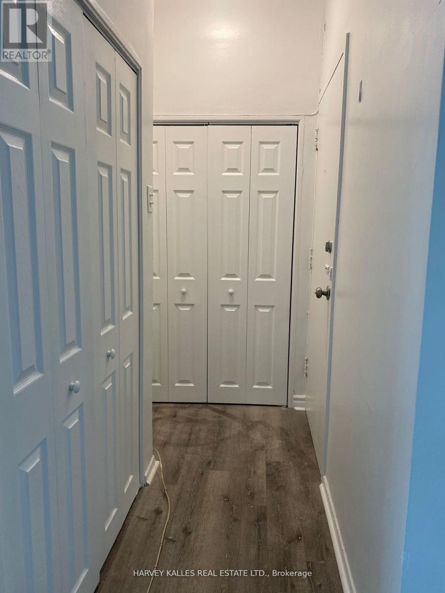 A hallway with white doors and a wooden floor.