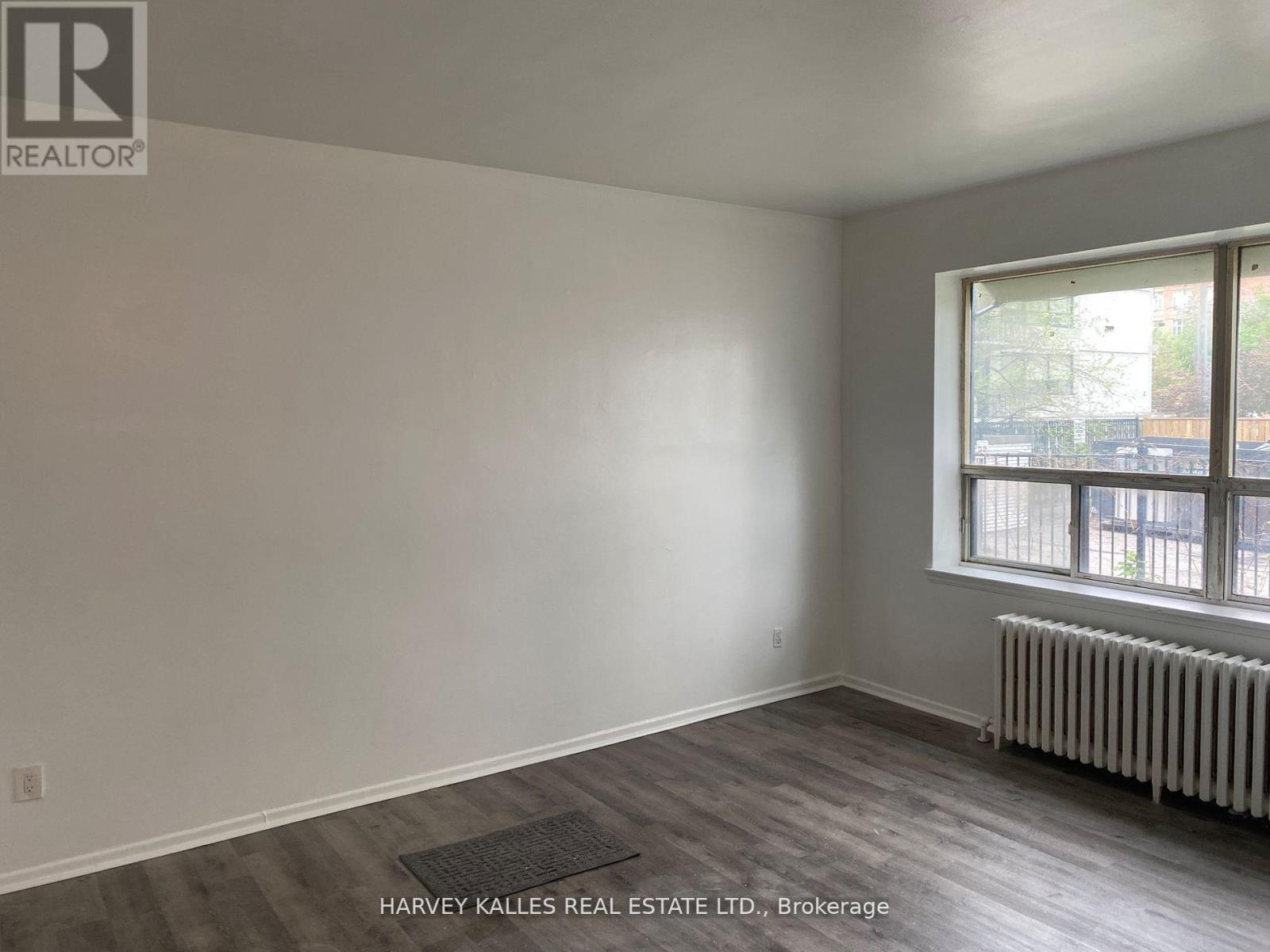 A room with a window and a radiator on the floor.