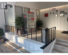 A real estate office with a black railing and a red mailbox.