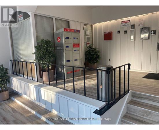 A real estate office with a black railing and a red mailbox.