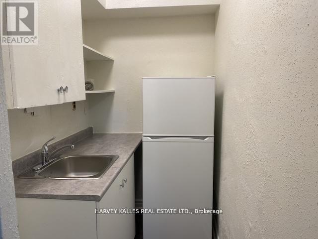 A small kitchen with a sink and a refrigerator.