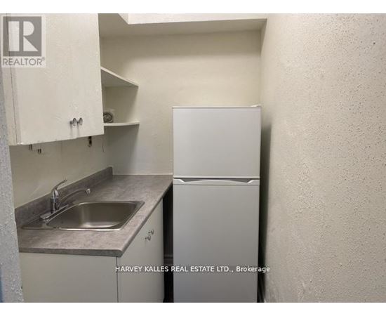 A small kitchen with a sink and a refrigerator.