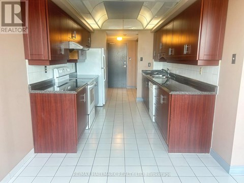 A kitchen with wooden cabinets and a tile floor.