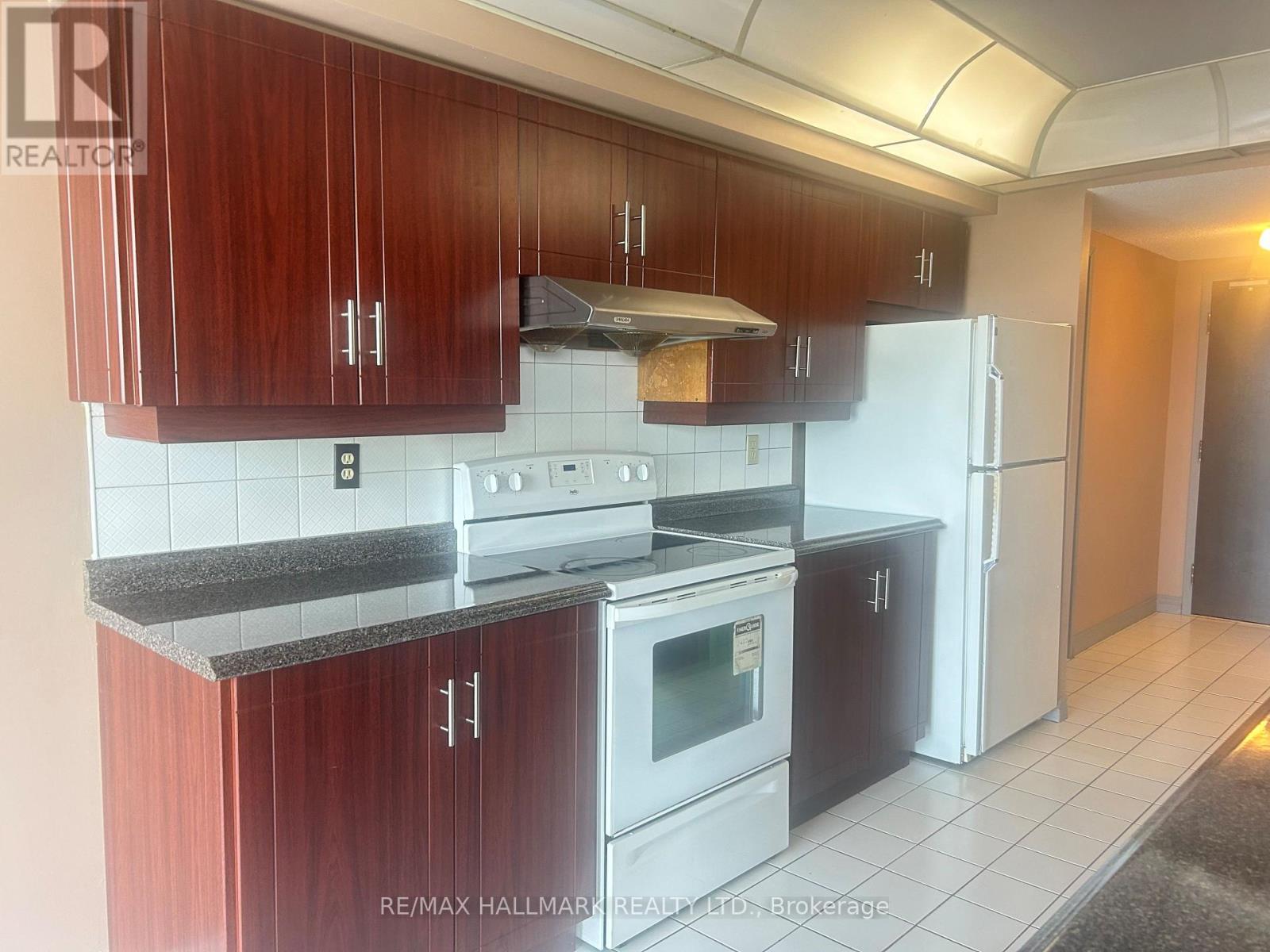 A kitchen with wooden cabinets and white appliances.