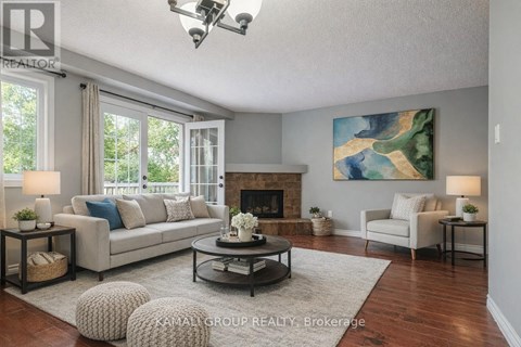 A well-lit living room with a fireplace and a painting on the wall.