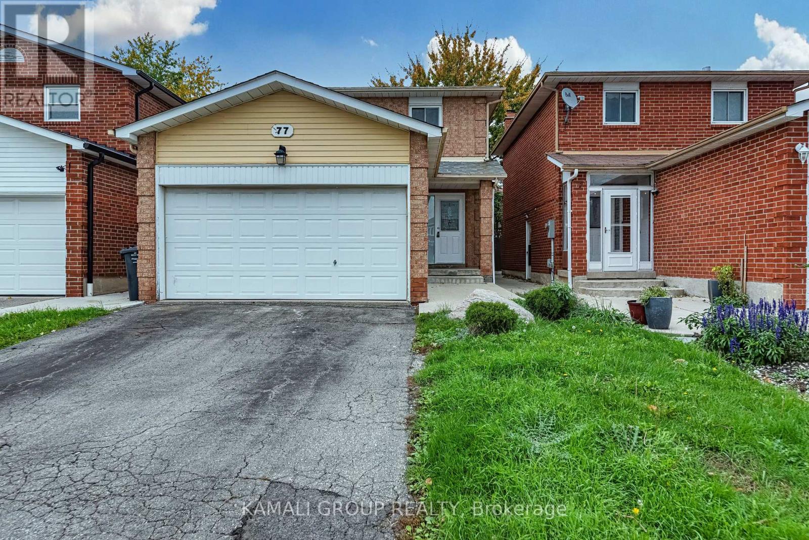 A residential house with a driveway in front.