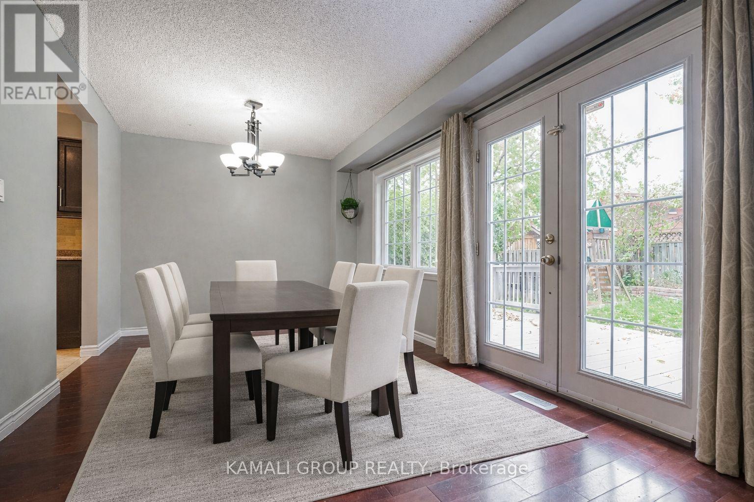A dining room with a table and chairs and a chandelier.