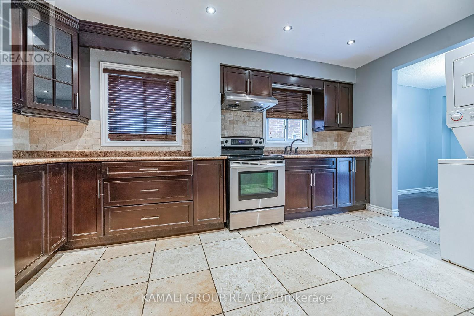 A kitchen with brown cabinets and a tiled floor.