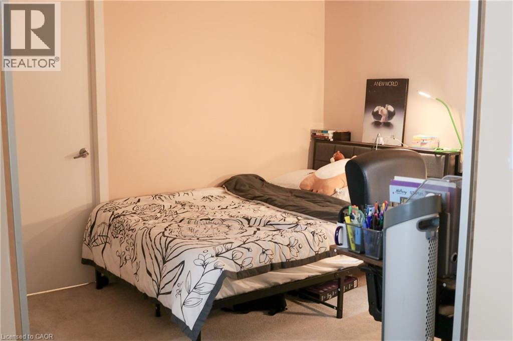 A bedroom with a bed, nightstand, and a lamp.