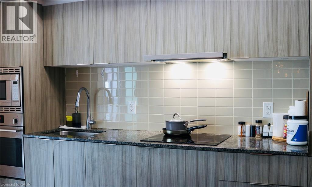 A kitchen with a black granite countertop and white cabinets.