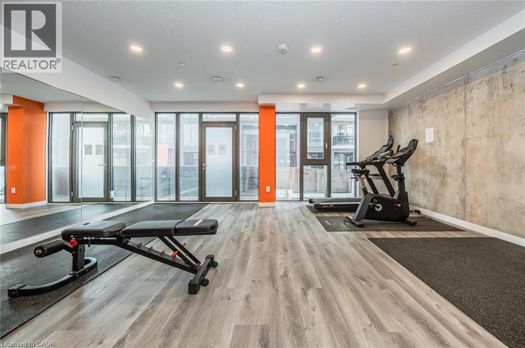 A gym with a treadmill, elliptical trainer and a bench press.