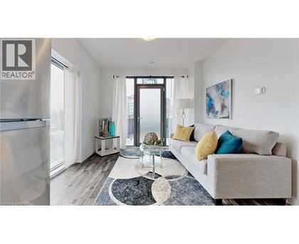 A living room with a grey couch and a rug.