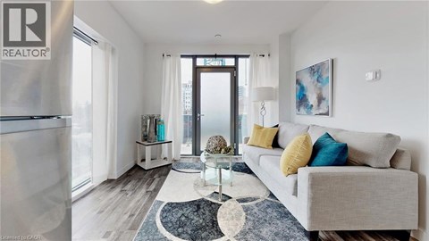 A living room with a grey couch and a rug.
