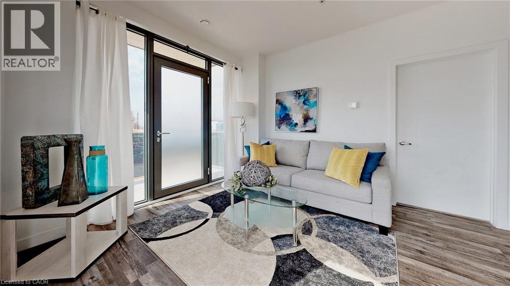 A living room with a grey couch, a glass table, and a rug.