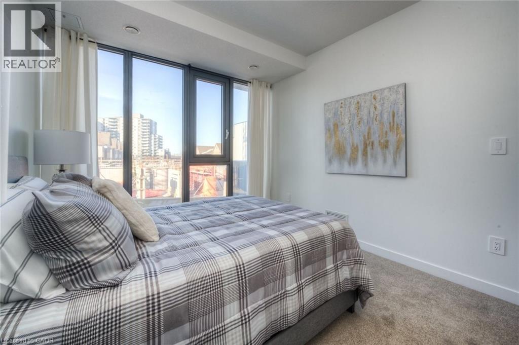 A bedroom with a large bed and a painting on the wall.