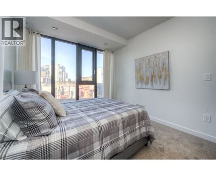 A bedroom with a large bed and a painting on the wall.