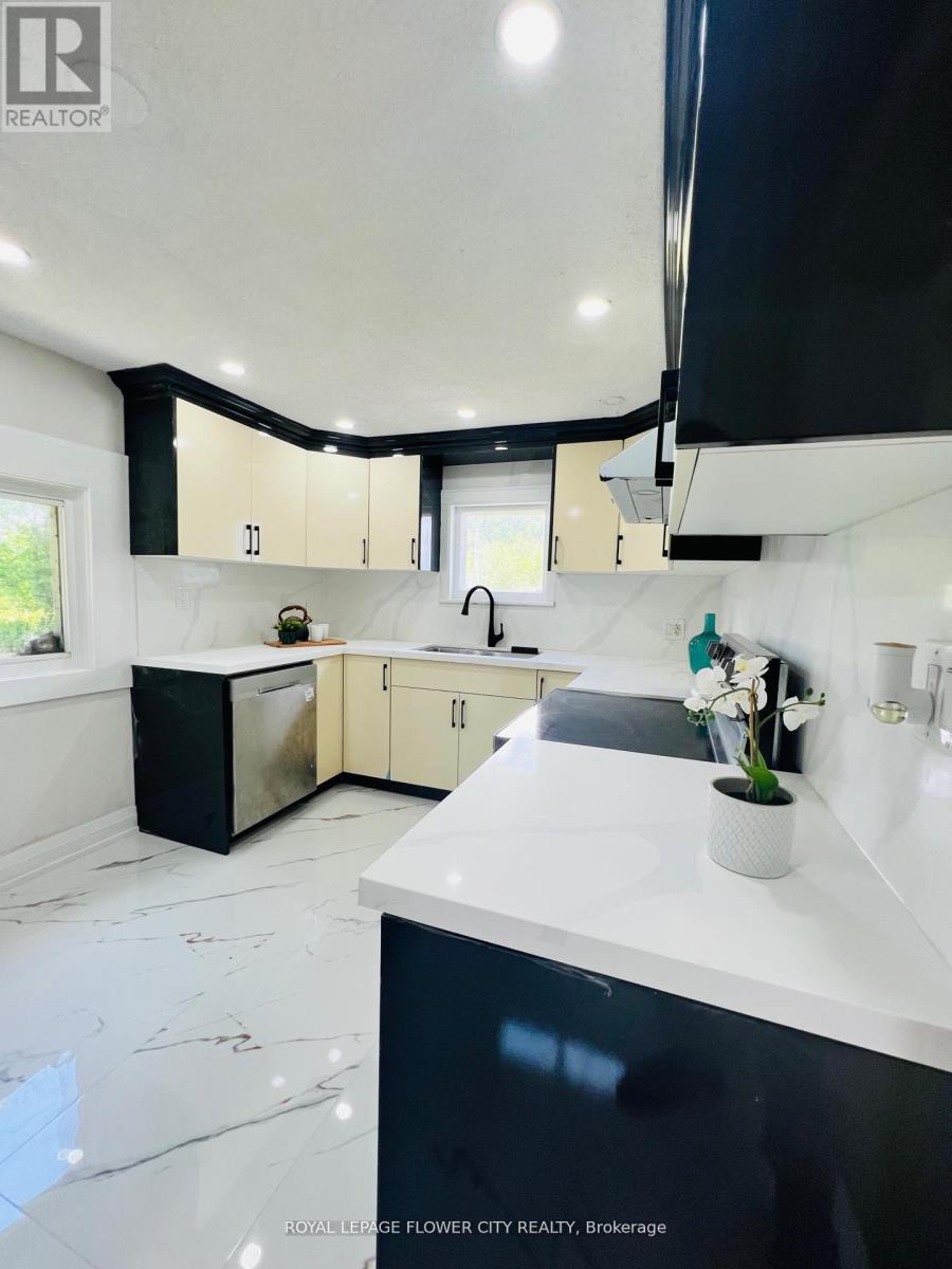 A modern kitchen with black and white cabinets and a marble floor.